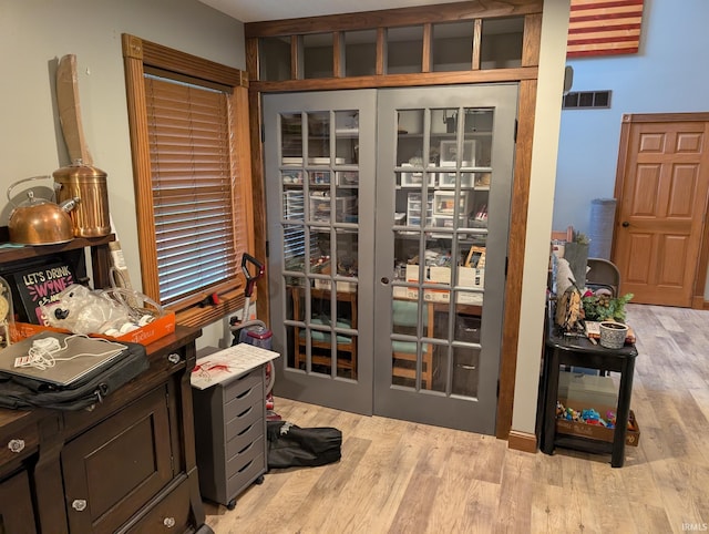 interior space featuring french doors, wood finished floors, and visible vents