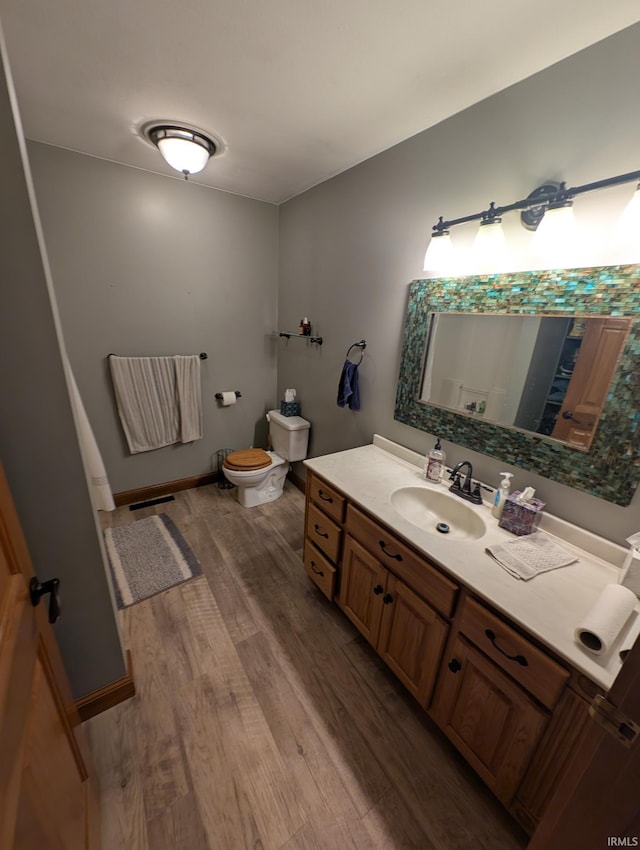 bathroom with visible vents, wood finished floors, vanity, and toilet