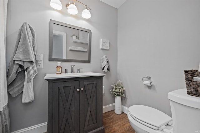 6891 E Hopewell Rd, Avilla, IN 46710 - bathroom featuring toilet, vanity, wood finished floors, and baseboards