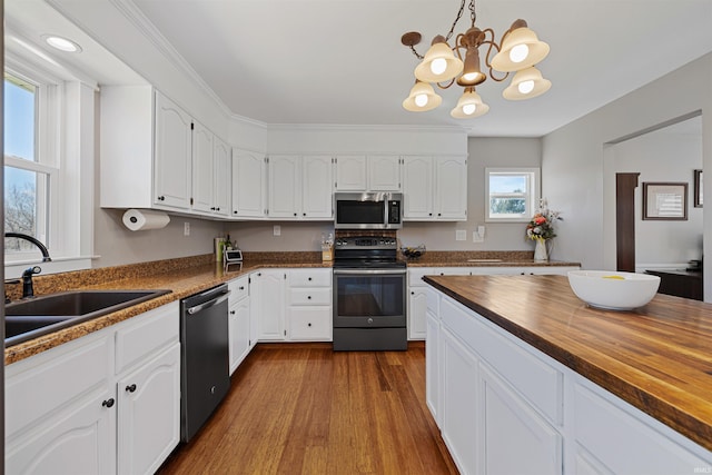 6891 E Hopewell Rd, Avilla, IN 46710 - kitchen featuring a chandelier, a sink, wood counters, appliances with stainless steel finishes, and white cabinetry