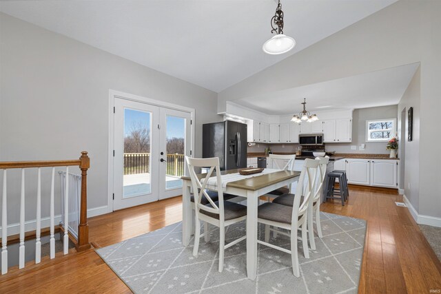 6891 E Hopewell Rd, Avilla, IN 46710 - dining space featuring a chandelier, light wood-type flooring, a wealth of natural light, and lofted ceiling