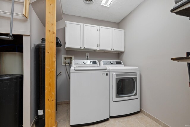 6891 E Hopewell Rd, Avilla, IN 46710 - clothes washing area with washer and dryer, baseboards, cabinet space, and light tile patterned floors