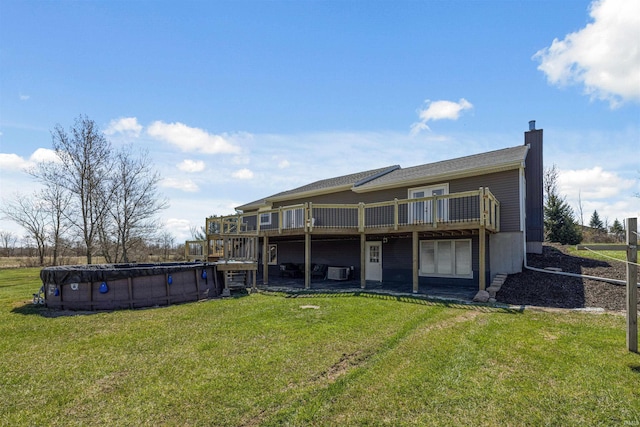 6891 E Hopewell Rd, Avilla, IN 46710 - back of property with a lawn, a covered pool, a chimney, and a deck
