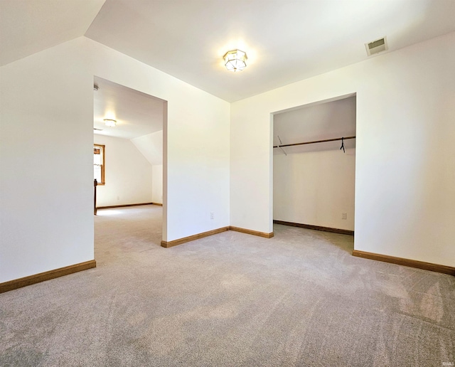 unfurnished bedroom featuring lofted ceiling, carpet flooring, visible vents, and baseboards