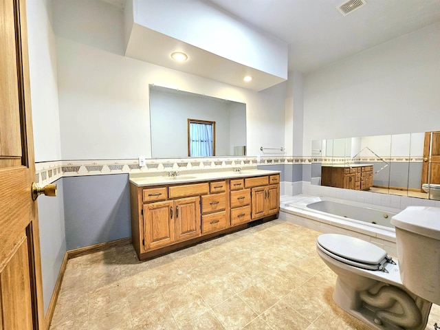 bathroom featuring recessed lighting, a whirlpool tub, double vanity, visible vents, and a sink