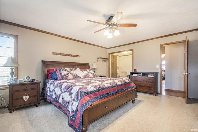 bedroom with light carpet, baseboards, ceiling fan, ensuite bath, and ornamental molding