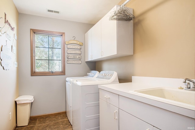 laundry area featuring a sink, cabinet space, washing machine and dryer, baseboards, and visible vents
