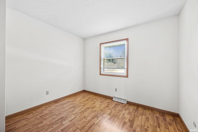 unfurnished room with baseboards, visible vents, and light wood-style floors
