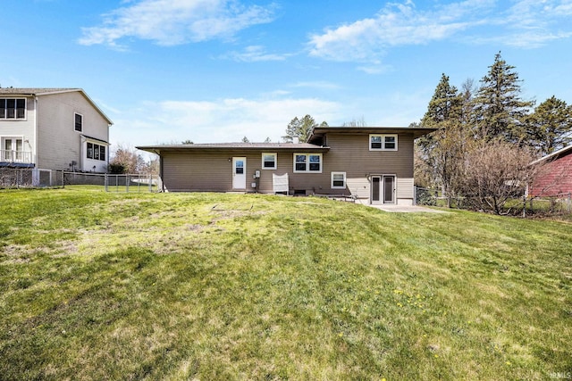 rear view of house featuring fence and a yard
