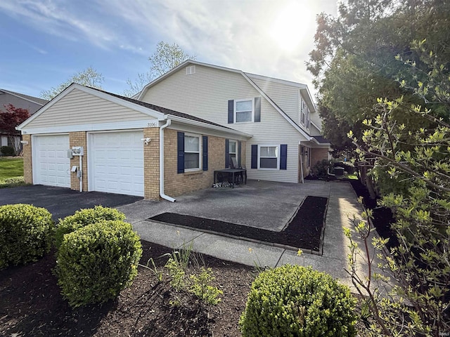 3106 S Carnaby St, Bloomington, IN 47401 - view of front of home featuring brick siding, a gambrel roof, aphalt driveway, and a garage