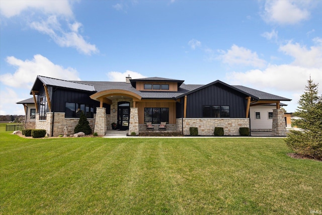 29929 Ridge Cv, Granger, IN 46530 - view of front of house with board and batten siding, roof with shingles, stone siding, and a front lawn