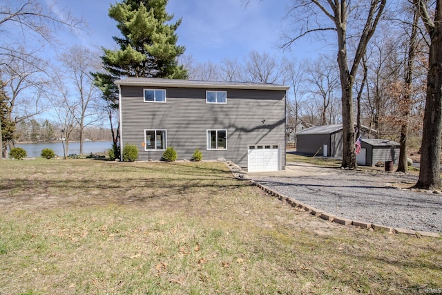 10510 E Orange St, Monterey, IN 46960 - rear view of house featuring an attached garage, aphalt driveway, a storage shed, an outdoor structure, and a yard
