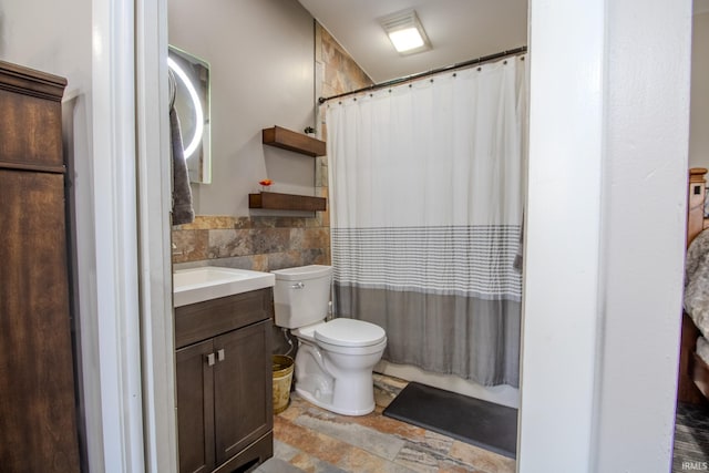 10510 E Orange St, Monterey, IN 46960 - full bathroom with stone finish floor, tile walls, curtained shower, vanity, and toilet