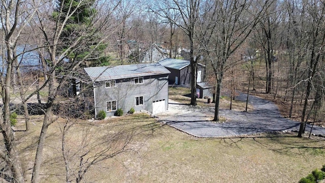 10510 E Orange St, Monterey, IN 46960 - view of side of home with an attached garage, a shed, driveway, and metal roof