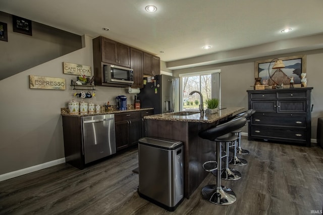 10510 E Orange St, Monterey, IN 46960 - kitchen with dark wood-style flooring, appliances with stainless steel finishes, a breakfast bar area, and dark brown cabinets