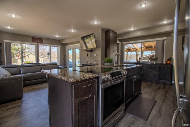 10510 E Orange St, Monterey, IN 46960 - kitchen featuring dark wood finished floors, an island with sink, dark stone countertops, electric stove, and recessed lighting