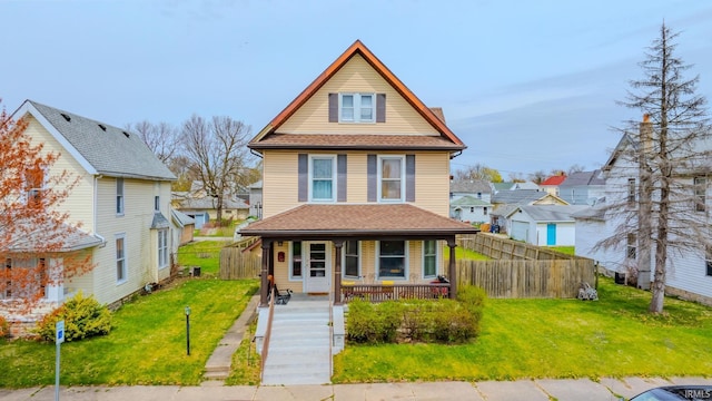 view of front of home featuring a porch, a front lawn, fence, and a residential view