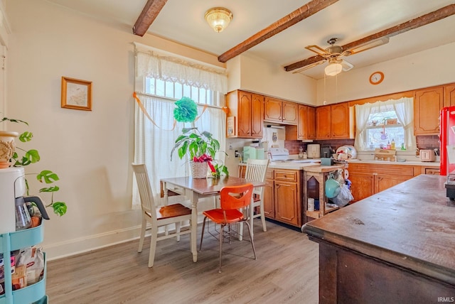 kitchen featuring brown cabinetry, decorative backsplash, light wood-style floors, ceiling fan, and beam ceiling