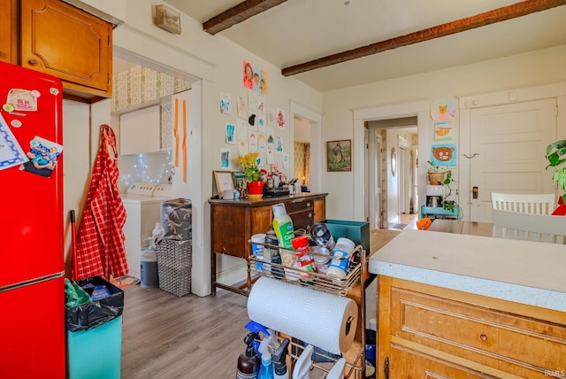misc room with beamed ceiling, light wood finished floors, and separate washer and dryer