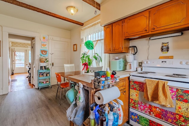 kitchen with light countertops, wood finished floors, electric range, and brown cabinetry
