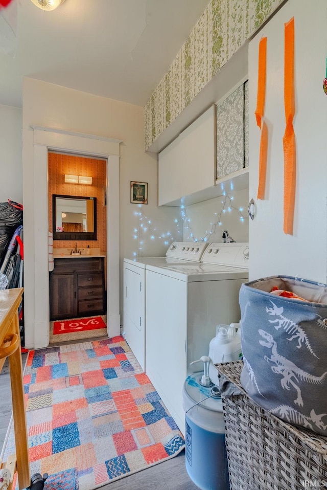 laundry area with cabinet space, a sink, and washer and clothes dryer