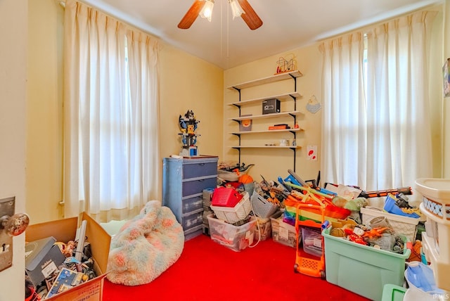 carpeted bedroom with ceiling fan and multiple windows