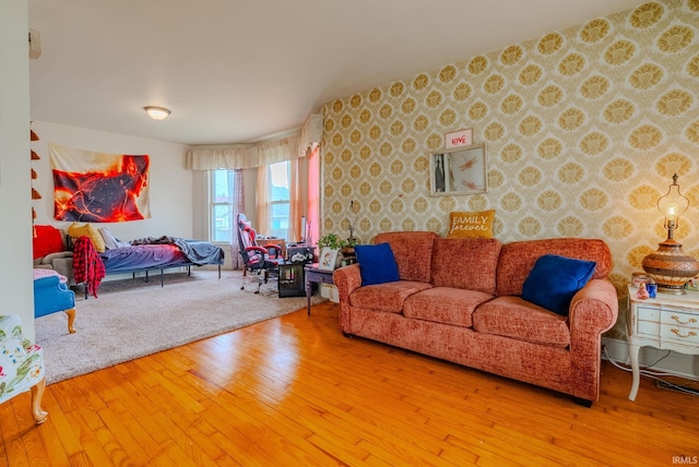 living room with wood-type flooring and wallpapered walls