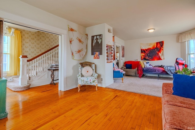living room featuring wallpapered walls, stairway, and wood-type flooring