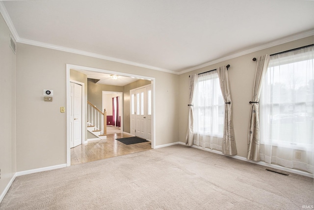 22486 Fireside Dr, Goshen, IN 46528 - carpeted empty room with stairway, visible vents, baseboards, and ornamental molding
