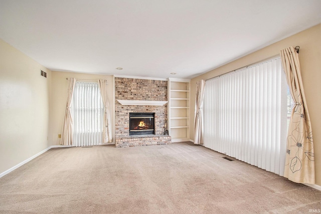 22486 Fireside Dr, Goshen, IN 46528 - unfurnished living room with carpet flooring, visible vents, baseboards, built in features, and a fireplace