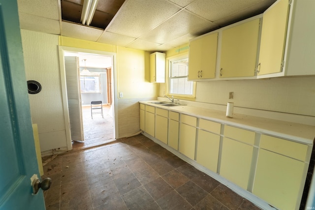 kitchen featuring light countertops, a drop ceiling, and a sink