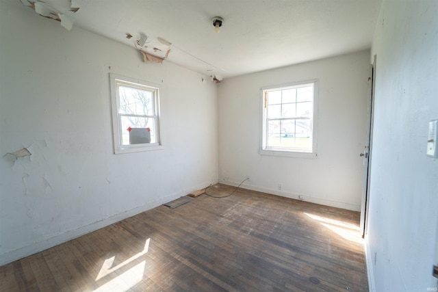 empty room with hardwood / wood-style floors, a healthy amount of sunlight, and baseboards