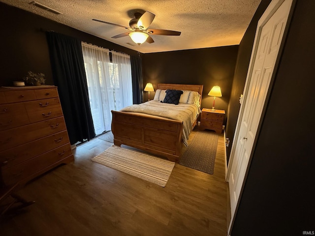 bedroom featuring a textured ceiling, wood finished floors, and visible vents