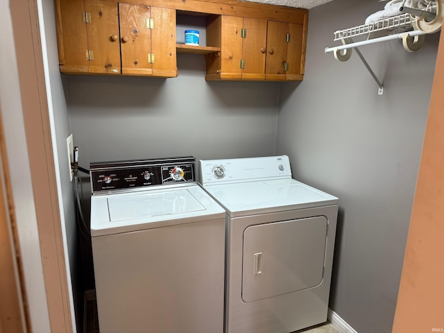 laundry room with independent washer and dryer and cabinet space