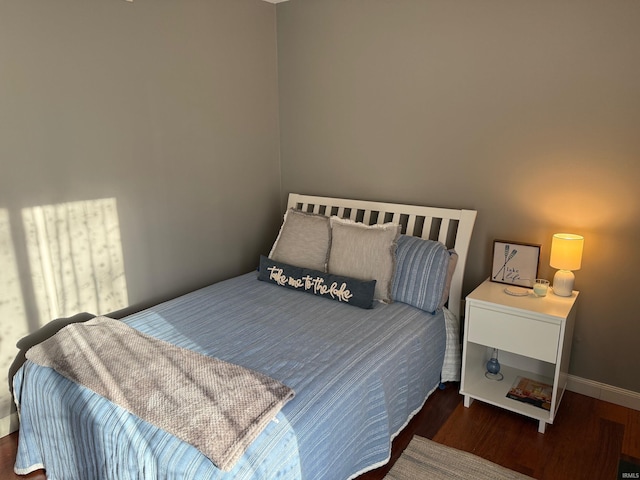 bedroom featuring wood finished floors and baseboards