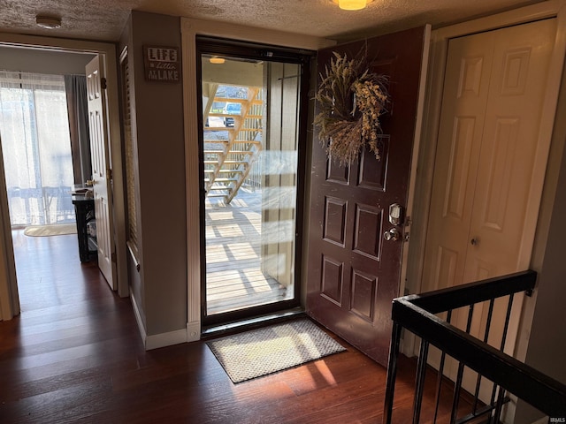 foyer featuring baseboards, a textured ceiling, and dark wood-style floors