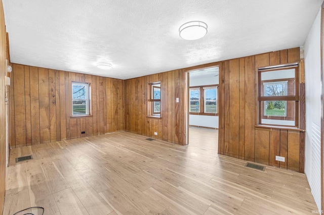 8763 E Backwater Rd, North Webster, IN 46555 - empty room featuring visible vents, light wood finished floors, and a wealth of natural light