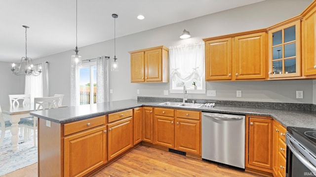 kitchen featuring an inviting chandelier, dark countertops, stainless steel dishwasher, a sink, and a peninsula