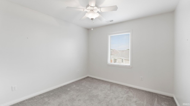 empty room featuring visible vents, a ceiling fan, baseboards, and light colored carpet