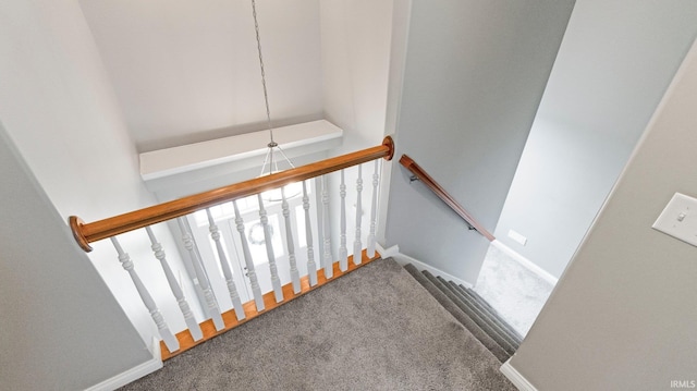 stairway with baseboards and carpet flooring