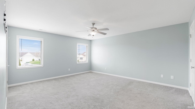 spare room featuring baseboards, a ceiling fan, and carpet