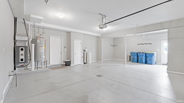 garage featuring baseboards, water heater, and a garage door opener