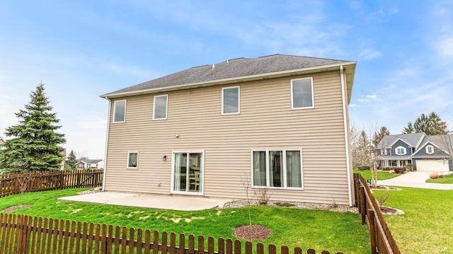 rear view of property featuring a lawn, fence, and a patio area