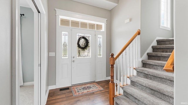 entryway featuring stairway, baseboards, hardwood / wood-style floors, and visible vents