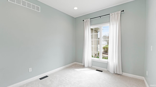 carpeted spare room featuring baseboards and visible vents