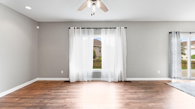 empty room with baseboards, a ceiling fan, wood finished floors, and recessed lighting