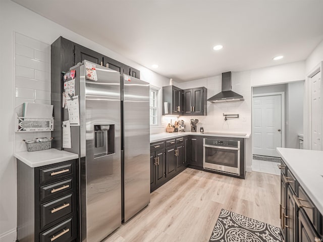 8013 Larch Ln, Evansville, IN 47710 - kitchen with wall chimney exhaust hood, stainless steel appliances, light countertops, and light wood-style floors