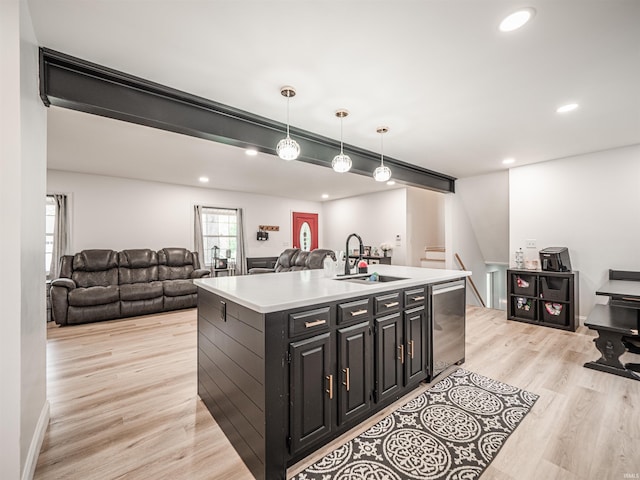 8013 Larch Ln, Evansville, IN 47710 - kitchen with stainless steel dishwasher, a sink, open floor plan, light wood-style flooring, and dark cabinets