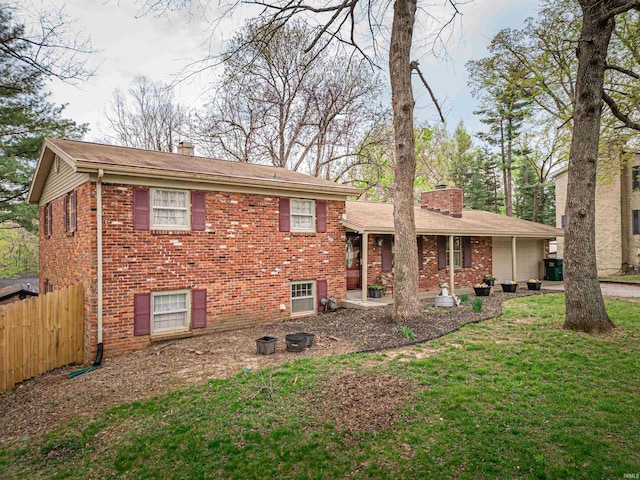 8013 Larch Ln, Evansville, IN 47710 - rear view of property with brick siding, a lawn, a chimney, and fence