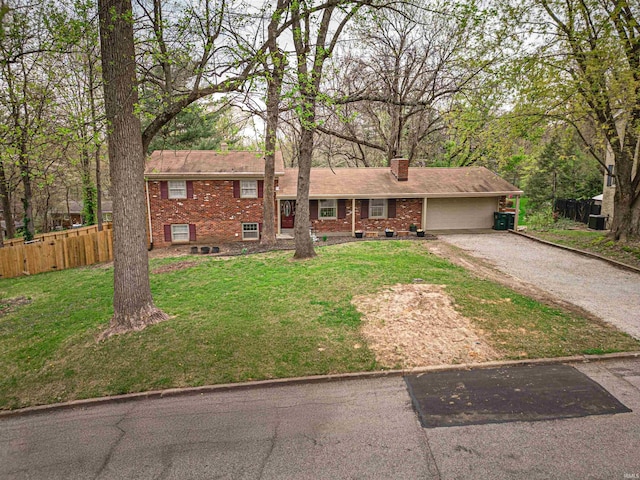 8013 Larch Ln, Evansville, IN 47710 - tri-level home featuring gravel driveway, fence, a front lawn, brick siding, and a garage